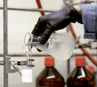 Chemical poured from beaker into test tube